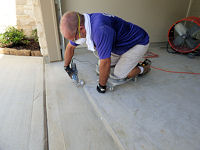 Hand-grinding and scrubbing a garage concrete floor, prior to ColorFlake epoxy application